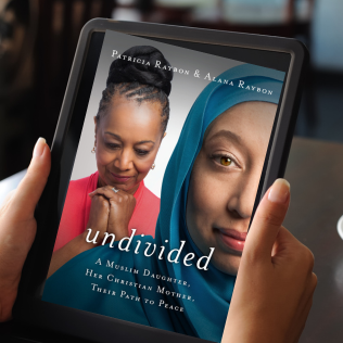 Image shows book cover of "Undivided: A Muslim Daughter, Her Christian Mother, Their Path to Peace" by Patricia Raybon. Book cover, shown in an ebook format, is being held by the hands of the person reading it.